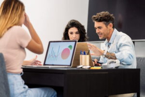 Equipo de una agencia de marketing trabajando en estrategia digital para empresas frente a un ordenador con gráficas de resultados