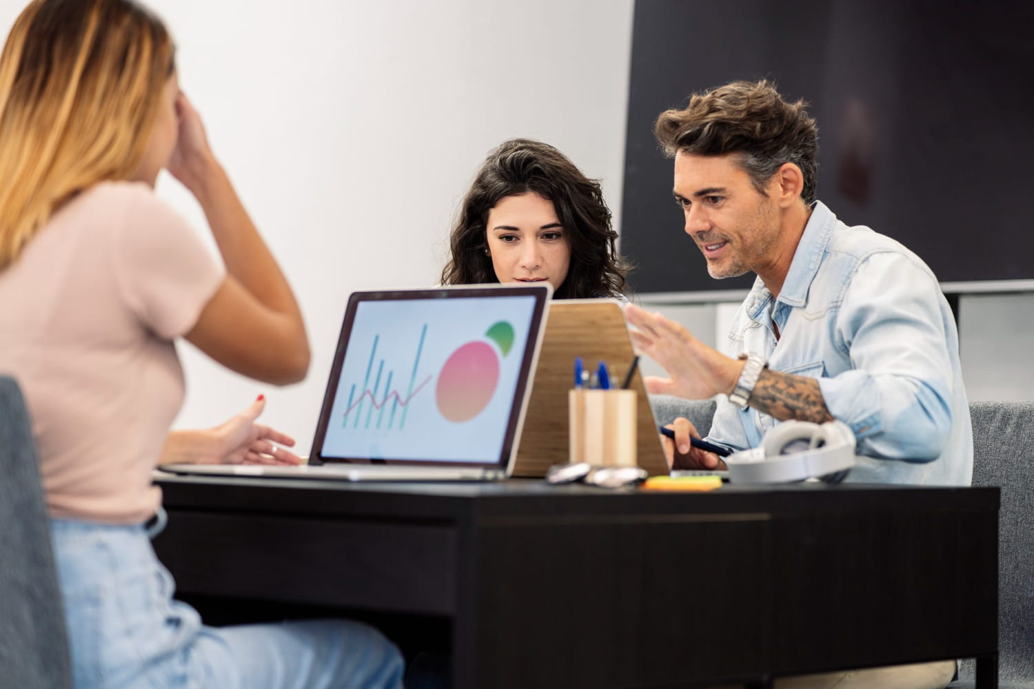 Equipo de una agencia de marketing trabajando en estrategia digital para empresas frente a un ordenador con gráficas de resultados